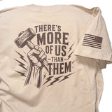 Tan t-shirt with graphic design and text that says There is More of Us than Them on the back.