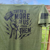 Olive Green t-shirt with graphic design and text saying "there is more of us than them." JRNYMN